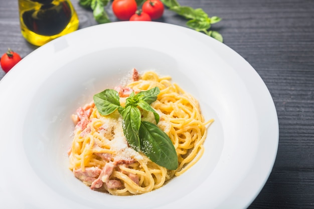 Free Photo | Spaghetti garnish with cheese and bail leaves in a white plate