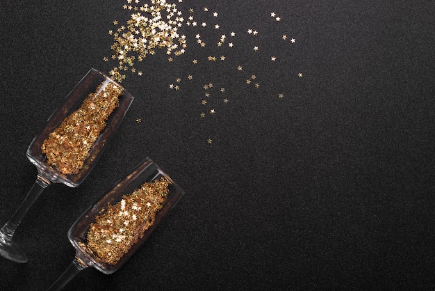 Spangles scattered from glasses on table Free Photo