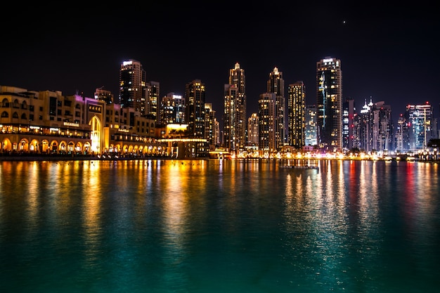 Sparkling dubai skyscrapers reflect in the water at night Free Photo