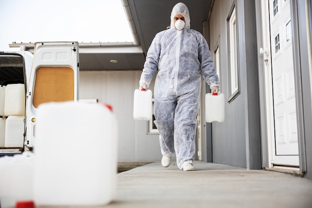 Premium Photo | Specialist in hazmat suits preparing for cleaning and ...