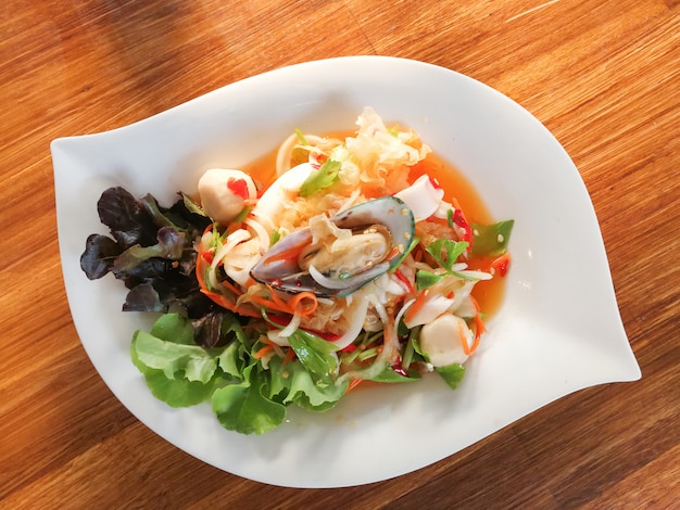 Spicy salad mix seafood plate with squid mussel shrimp and fresh vegetable served on dining table Premium Photo