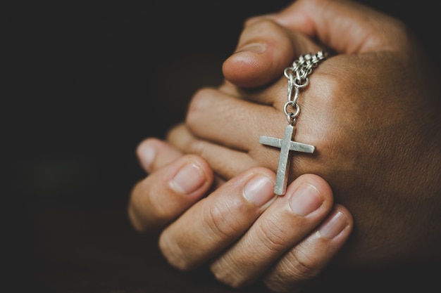 精神性と宗教 宗教概念の女性十字のシンボルを保持しながら神に祈る手 修道女は手に十字架をつかまえました 無料の写真