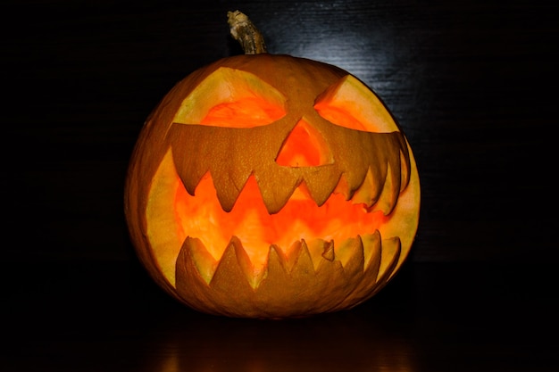 Premium Photo | Spooky luminous halloween pumpkin on black background