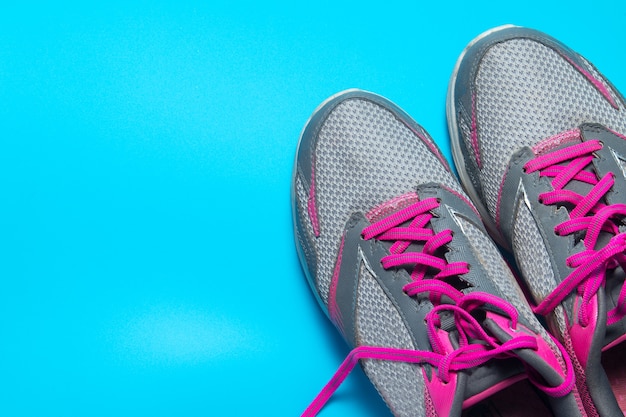 Premium Photo | Sport flat lay pink shoes on blue background with ...