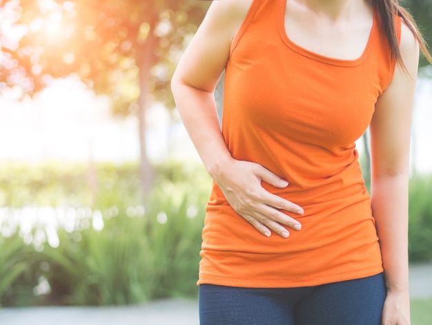 Premium Photo | Sport girl have stomach pain after jogging work out in ...