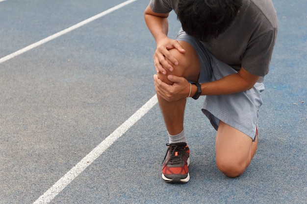 Sport man suffering with pain on sports running knee ...