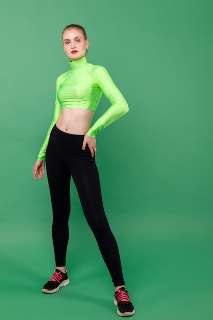 Premium Photo | Sporting slender girl in leggings on a green space