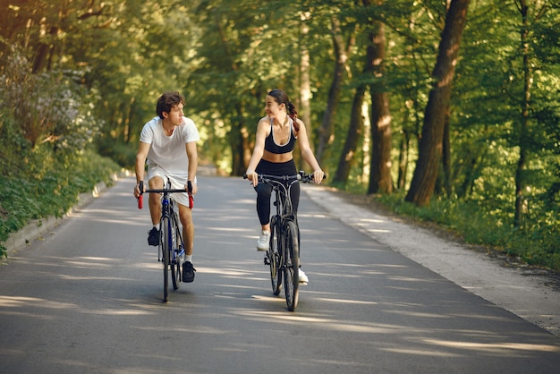 Sports couple riding bikes in summer forest Free Photo
