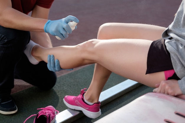 Sports doctor treating injured sportman's knee. Premium Photo