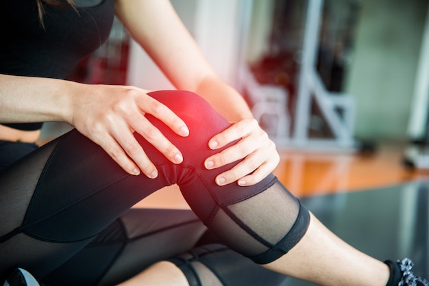 Sports injury at knee in fitness training gym. Training and medical concept Premium Photo