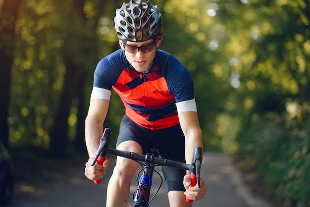 Sports man riding bike in summer forest Free Photo
