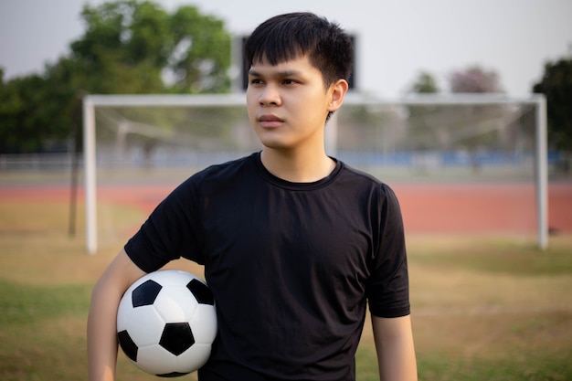 Premium Photo Sports And Recreation Concept A Male Teenager Using His Right Hand Holding A Ball In One Side In The Middle Of The Football Field