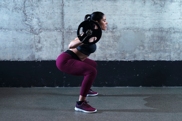 Free Photo | Sporty fitness woman in crouching position doing squats ...