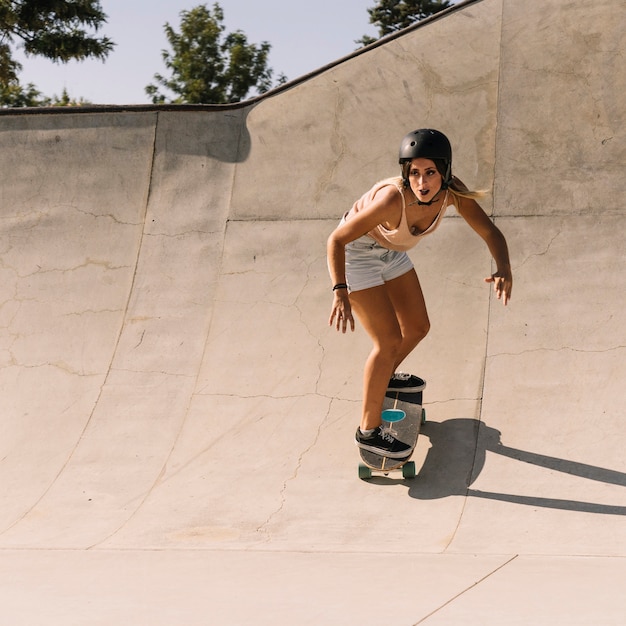 Free Photo | Sporty girl with helmet skating in half pipe