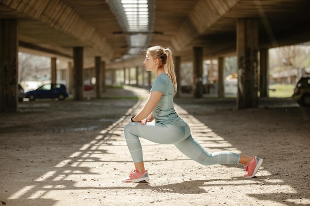 Premium Photo | Sporty woman stretching her legs outside fitness woman ...