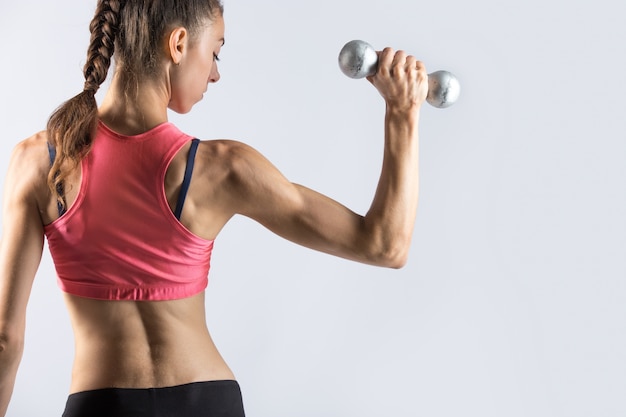 Sporty woman working out with weights. rear view Free Photo