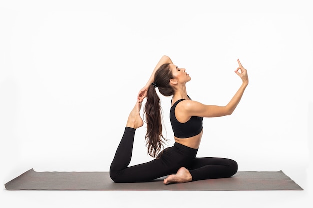 Sporty young woman doing yoga practice isolated on white surface - concept of healthy life and natural balance between body and mental development Free Photo