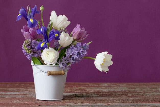 Premium Photo | Spring flowers in bucket on pink background