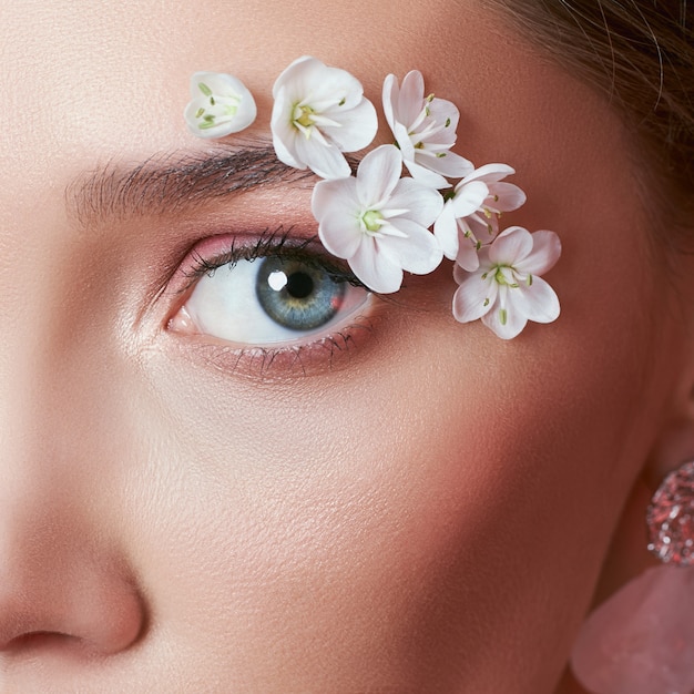 白い花と春のメイクの目の女性 プレミアム写真