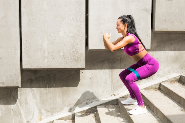 Premium Photo Squats Resistance Band Sporty Young Woman Doing Squat Exercise With Booty Band 