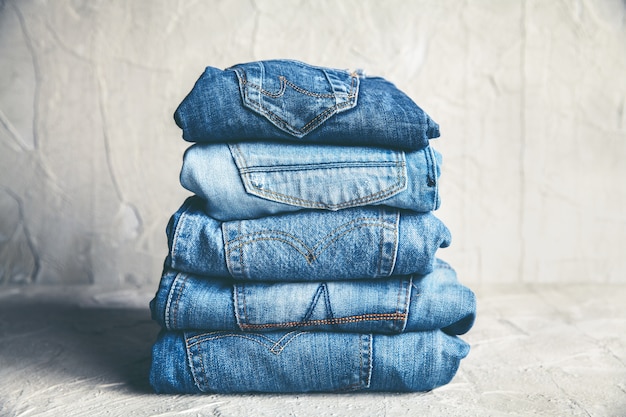 Premium Photo | Stack of blue jeans on a gray background