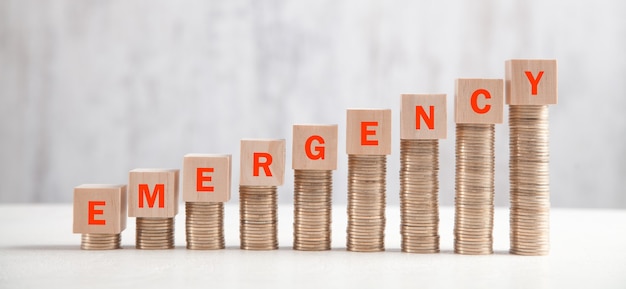Stack of coins with emergency text. Premium Photo