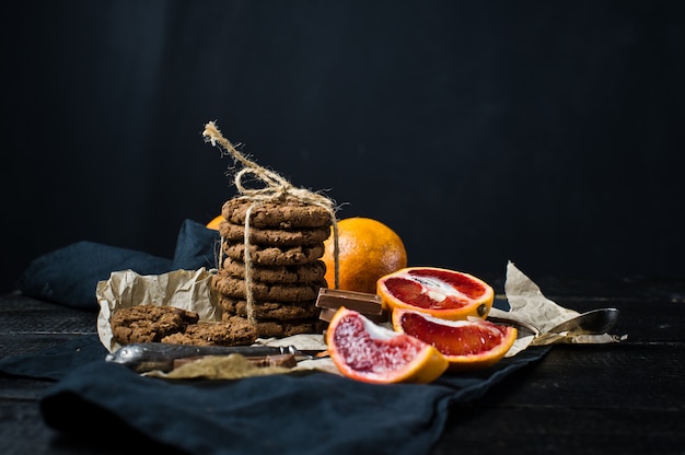 A stack of crunchy chocolate chip cookies with orange. Premium Photo