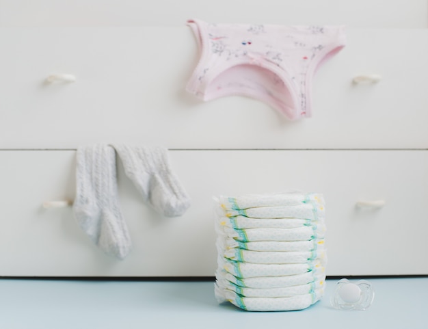 A stack of diapers and a locker with linens Premium Photo