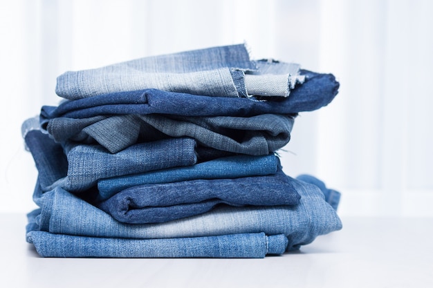 Premium Photo Stack Of Old Blue Jeans For Recycling On White Background