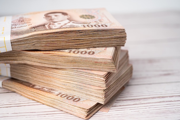 Premium Photo Stack Of Thai Baht Banknotes On Wooden premium-photo-stack-of-thai-baht-banknotes-on-wooden