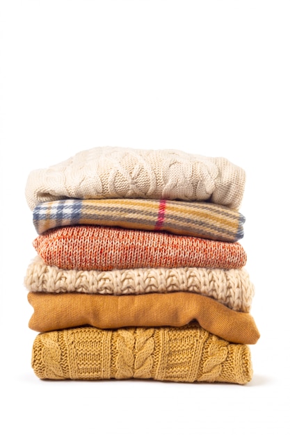 Premium Photo | Stack of various sweaters isolated on white