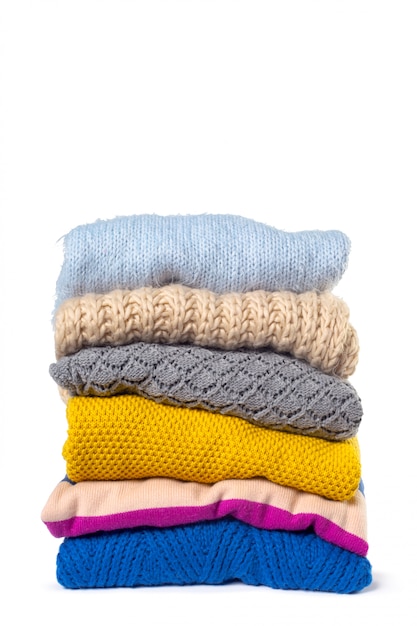 Stack of various sweaters isolated on white | Premium Photo