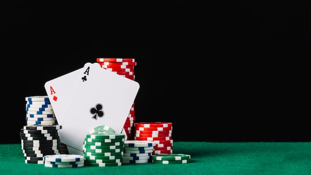 Premium Photo | Stack of white; green; black and red casino chips with two aces on poker table