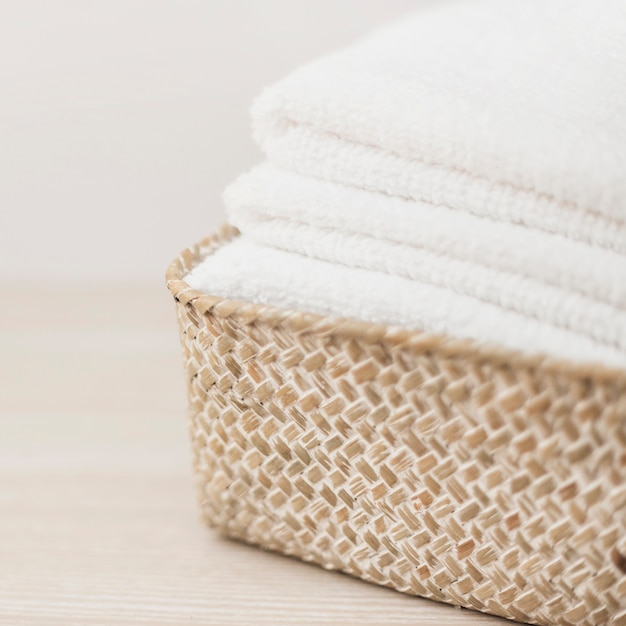 Stack of white towels in basket Free Photo