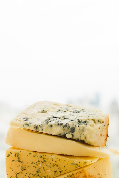 Stacked of triangular cheese slices against white background Free Photo