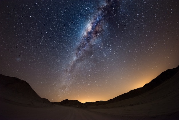 Starry sky and milky way arc, with details of its colorful core, outstandingly bright, captured from the namib desert in namibia, africa. the small magellanic cloud on the left hand side. Premium Photo
