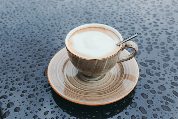 Premium Photo Steaming Coffee Cup On A Rainy Day Background