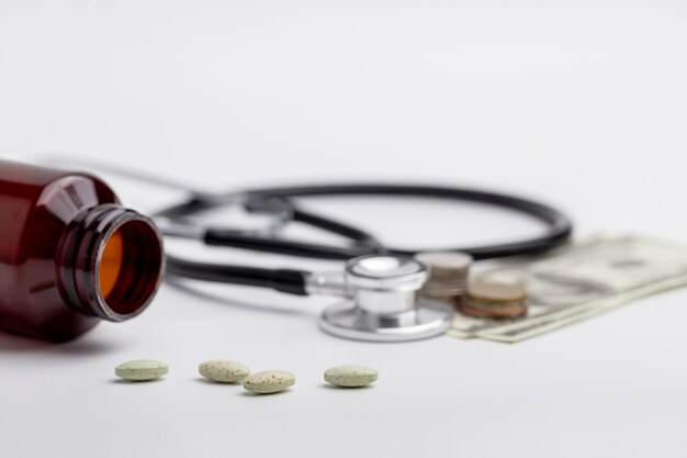 Premium Photo | Stethoscope and coins placed on banknotes as well as ...