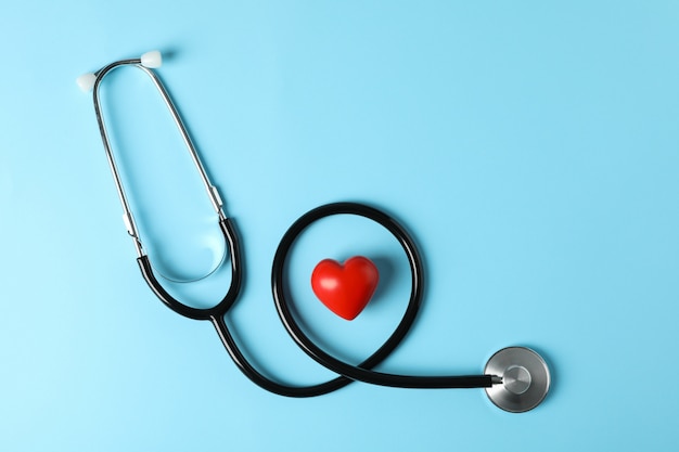 Premium Photo | Stethoscope and heart on blue background, top view