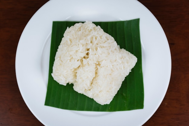 Premium Photo | Sticky rice on banana leaf and wooden background