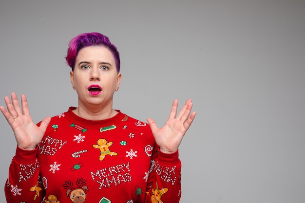 Premium Photo Stock Photo Of Astonished Happy Woman With Dyed Purple Hair Wearing Red Santa Hat And Red Christmas Jersey Holding Arms Half Bent In Excitement