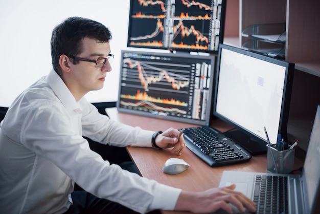 Stockbroker in shirt is working in a monitoring room with display screens. stock exchange trading forex finance graphic concept. businessmen trading stocks online Free Photo