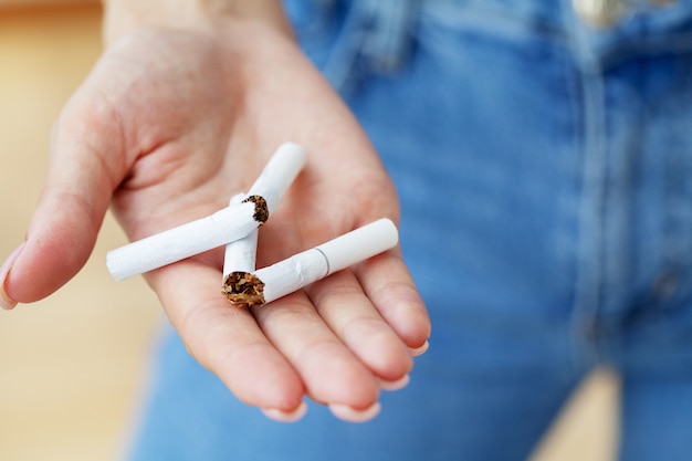 喫煙をやめる、壊れたタバコを保持している女性のクローズアップ プレミアム写真