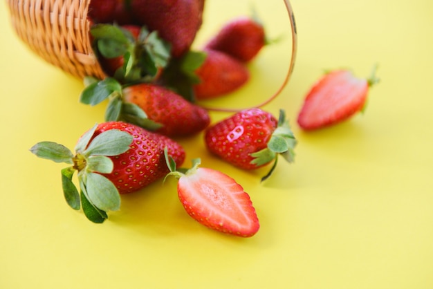 Strawberries fresh on yellow background. ripe red strawberry picking in basket Premium Photo