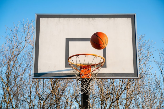 Premium Photo | Street basketball ball falling into the hoop.