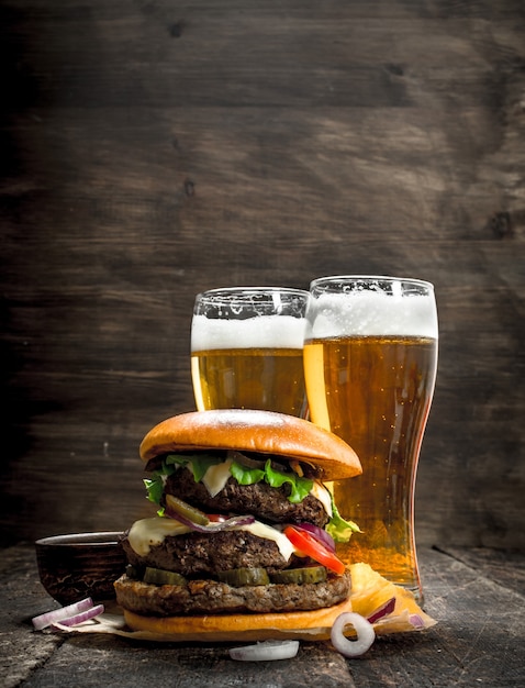 Premium Photo | Street food a big burger with glasses of light beer on ...