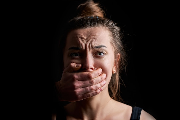 Premium Photo | Stressed unhappy scared crying woman victim in fear with closed mouth on a dark black