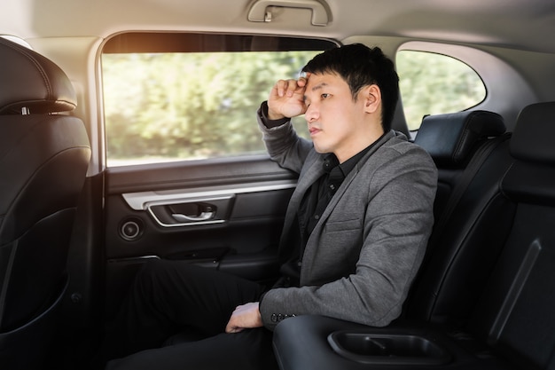 Premium Photo | Stressed young business man sitting in the back seat of car