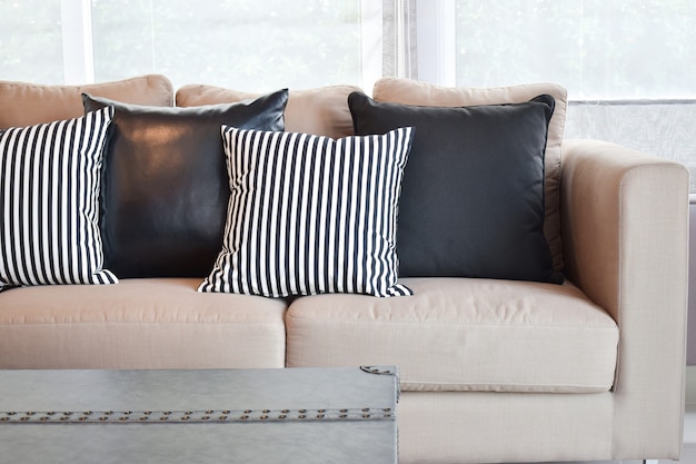 Premium Photo | Striped and black leather pillows on velvet beige sofa ...