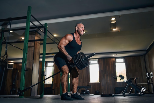 Premium Photo | Strong adult caucasian bald weightlifter works out with ...